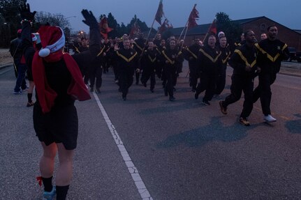 U.S. Army Col. Jenn Walkawicz, 733rd Mission Support Group commander, cheers on Soldiers as they finish the holiday 5K at Joint Base Langley-Eustis, Virginia, Dec. 13, 2019. Walkawicz announced that Charlie Company, 128th Aviation Battalion, 128th Avn. Brigade donated 3,533 toys to the 2019 Toys for Tots campaign before the 5K. (U.S. Air Force photo by Senior Airman Derek Seifert)