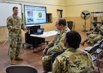 1st Lt. Robert Douty provides a presentation on the 110th IO Battalion’s support of the joint exercise Pacific Sentry, with U.S. Indo-Pacific Command and U.S. Army Pacific.  The Information Operations and Cyber Operations Symposium was held at the Annapolis Readiness Center, Nov. 17.