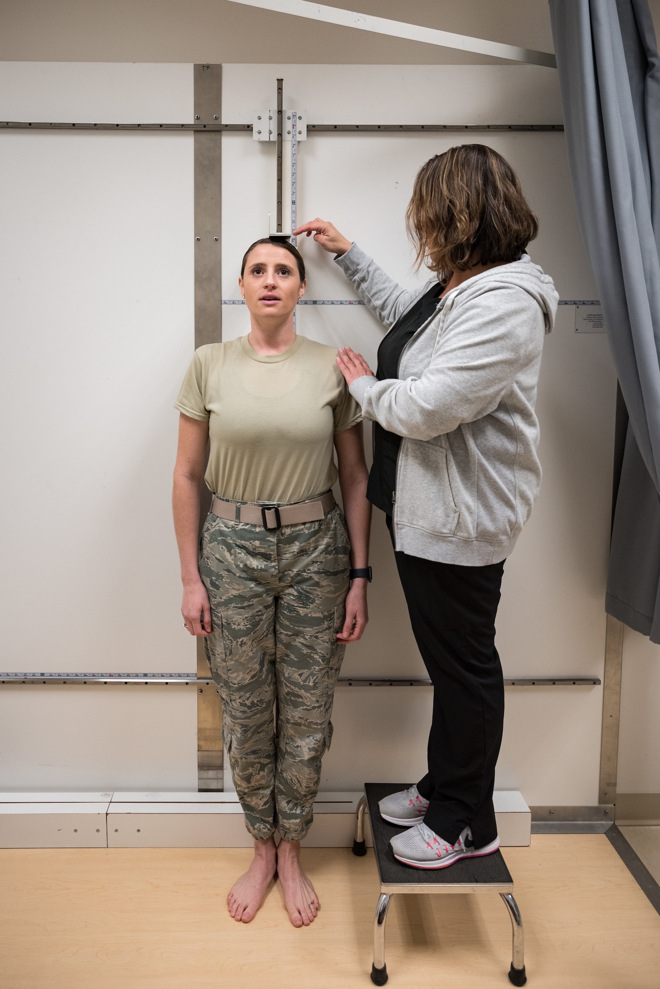 Jessica Barker, an aeromedical technician at the U.S. Air Force School of Aerospace Medicine, measures the standing height of a pilot candidate using the only official anthropometric device for measuring those who fall outside height standards. Seven measurements are collected and uploaded into a waiver system to determine if height for each candidate is truly an eliminating factor to fly manned aircraft. (U.S. Air Force photo by Richard Eldridge)