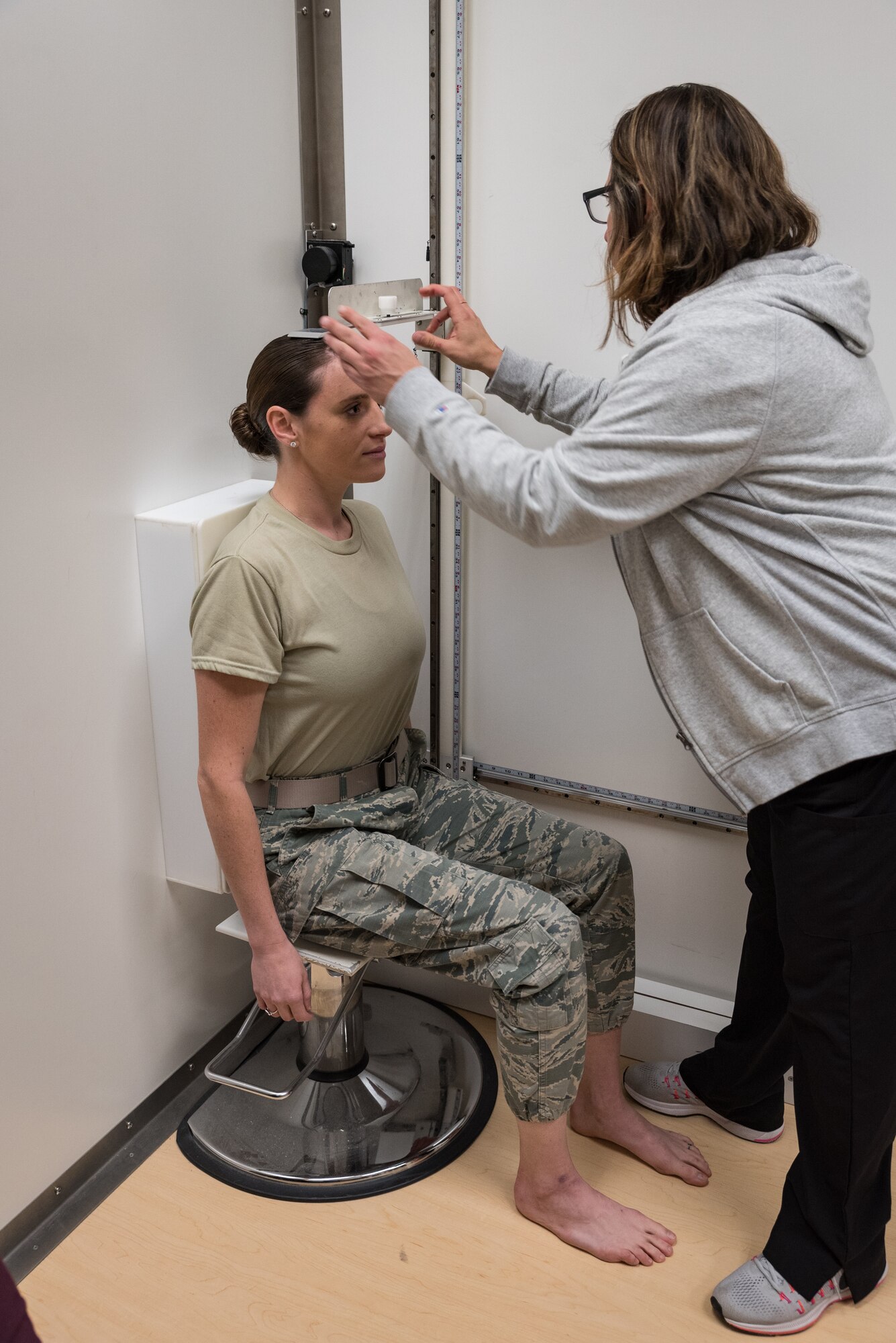 Jessica Barker, an aeromedical technician at the U.S. Air Force School of Aerospace Medicine, measures the sitting height of a pilot candidate using the only official anthropometric device for measuring those who fall outside height standards. Seven measurements are collected and uploaded into a waiver system to determine if height for each candidate is truly an eliminating factor to fly manned aircraft. (U.S. Air Force photo by Richard Eldridge)