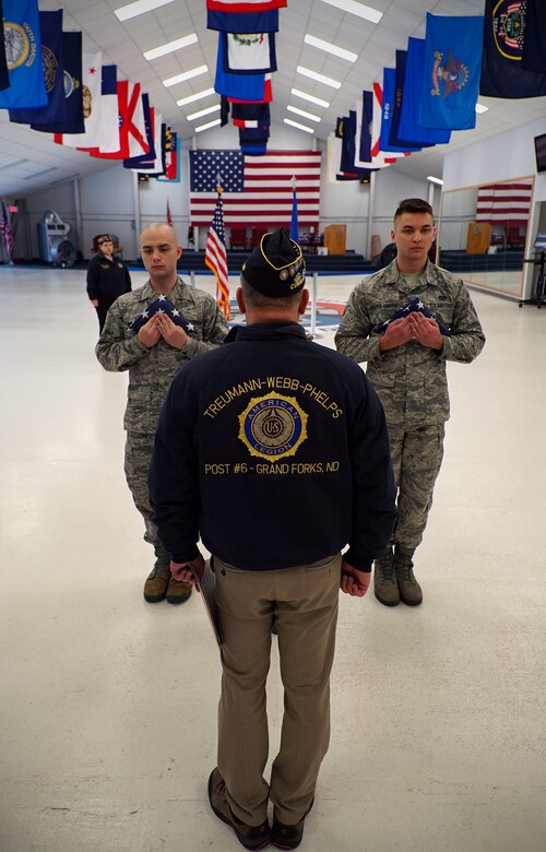 Robert Greene, American Legion Post 6 commander, center, conducts a ceremony for disposal of unserviceable flags Dec. 7, 2019, on Grand Forks Air Force Base, North Dakota. The base honor guard assisted with the ceremony, after which nearly 50 faded, worn or otherwise unserviceable flags were burned. (U.S. Air Force photo by Senior Airman Elora J. Martinez)