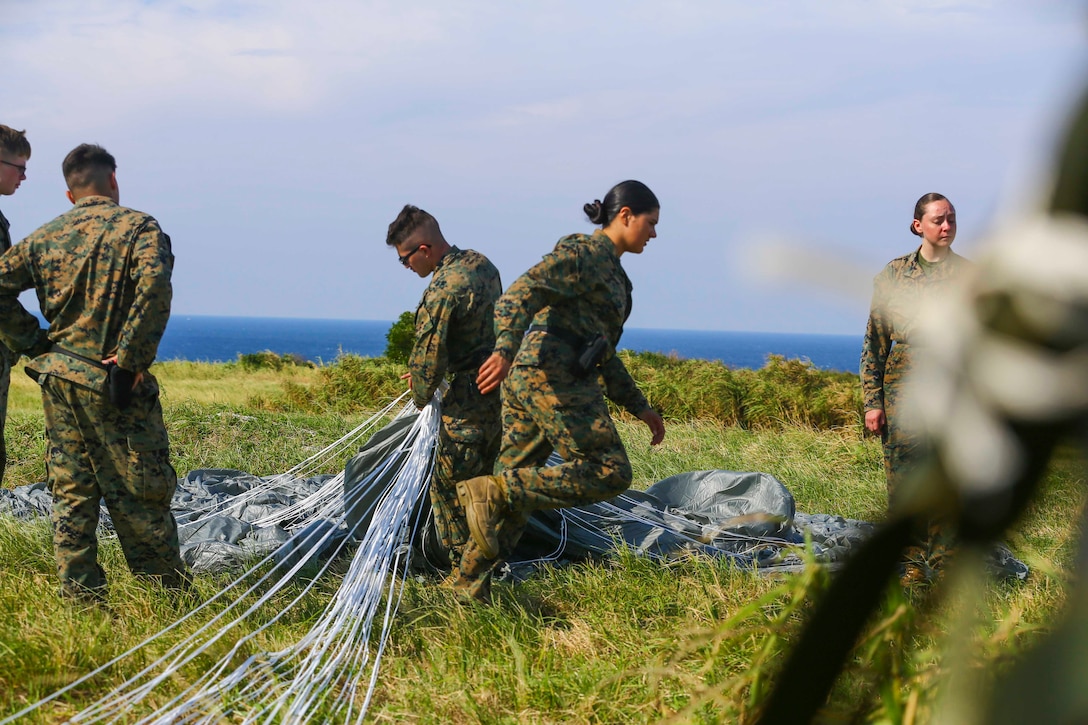 A group of Marines pack a parachute.