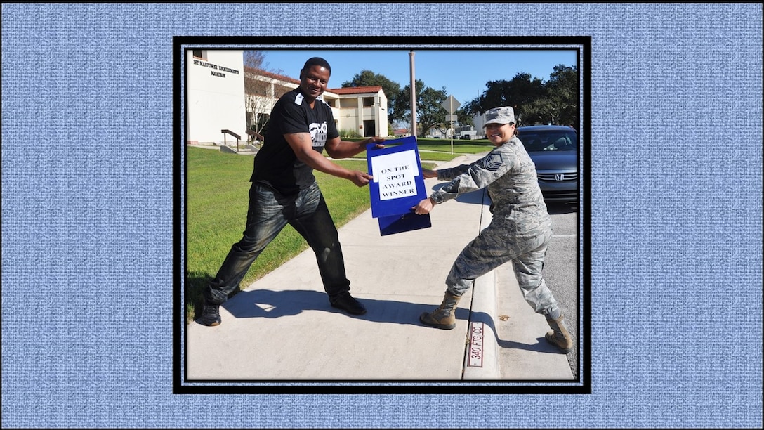 Master. Sgt. Julia Tovar (right) 340th FTG's December, On-the-Spot Award winner, claims the award parking sign from November's winner, Anthoney Smith. On the Spot Award winners get to park in the commander's parking slot for one week. (U.S. Air Force photo by Janis El Shabazz)