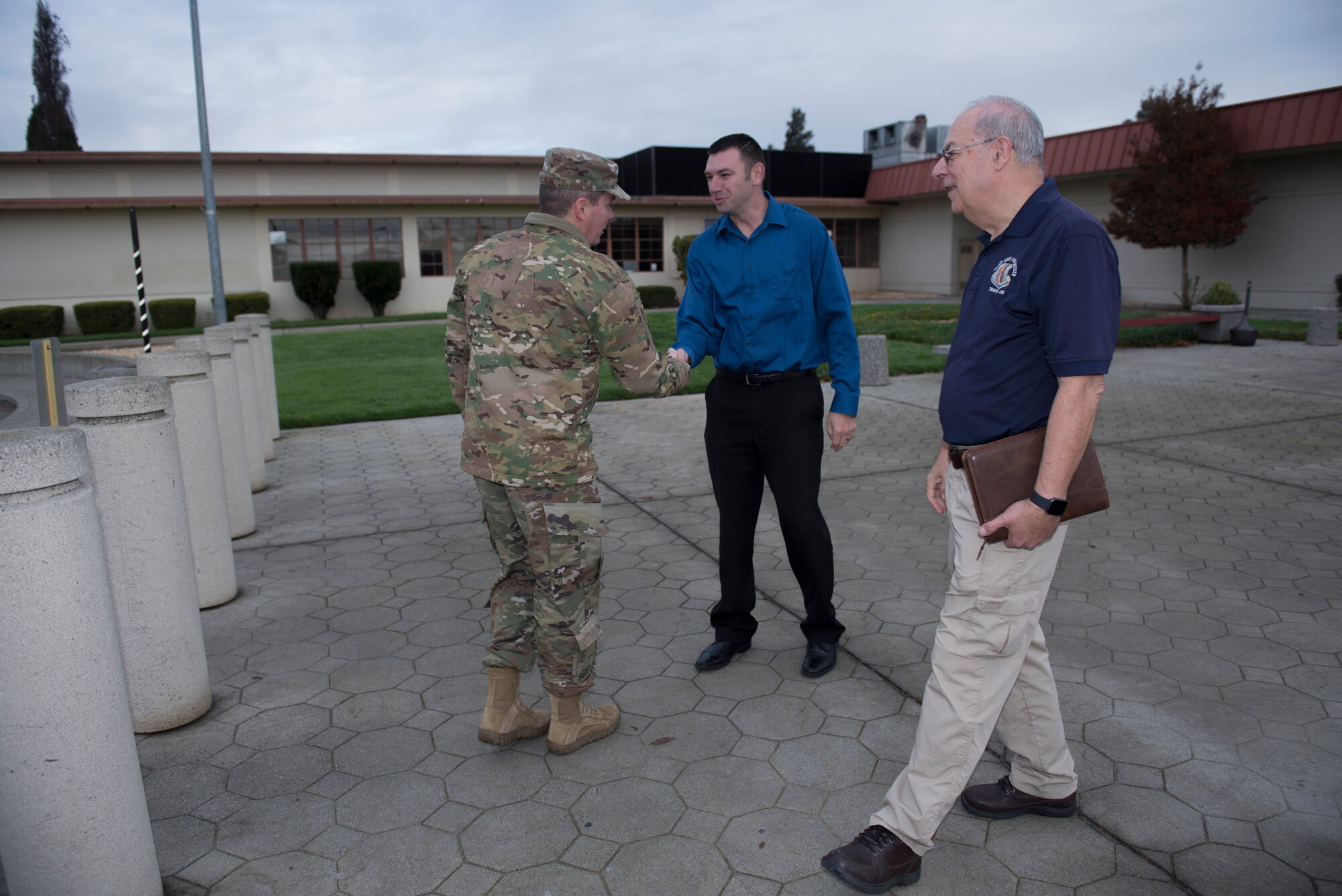 Jared Pitts, middle, International Treaty Compliance Office staff member, and Sal Pampinella, right, International Treaty Compliance Office staff member, greet Col. Jeffrey Nelson, left, 60th Air Mobility Wing commander, at the Passenger Terminal entrance Dec. 13, 2019, at Travis Air Force Base, California. Pitts and Pampinella manage and direct all activities that involve foreign visitors. Nelson toured the International Treaty Compliance Office as part of the Leadership Rounds, a program that allows base leadership to connect with personnel and gain a more in-depth understanding of each section on base. (U.S. Air Force photo by Airman 1st Class Cameron Otte)