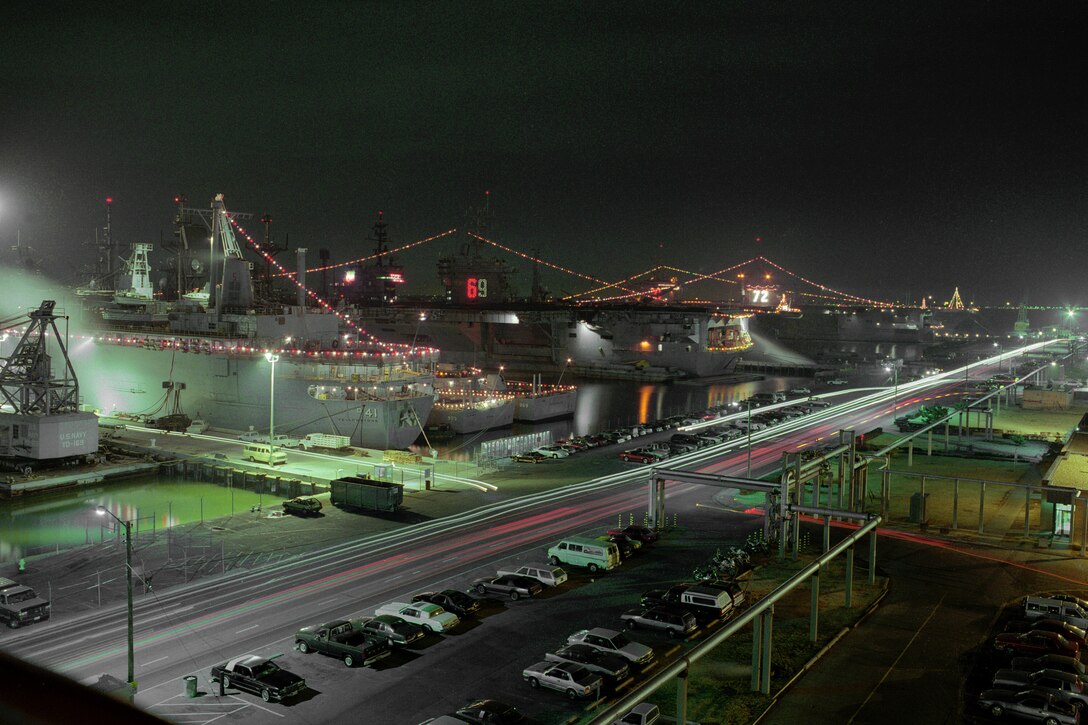 Lighted ships sit in a port.