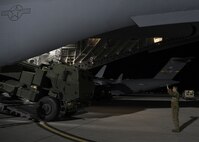 A person provides direction to a vehicle driving out of an aircraft.