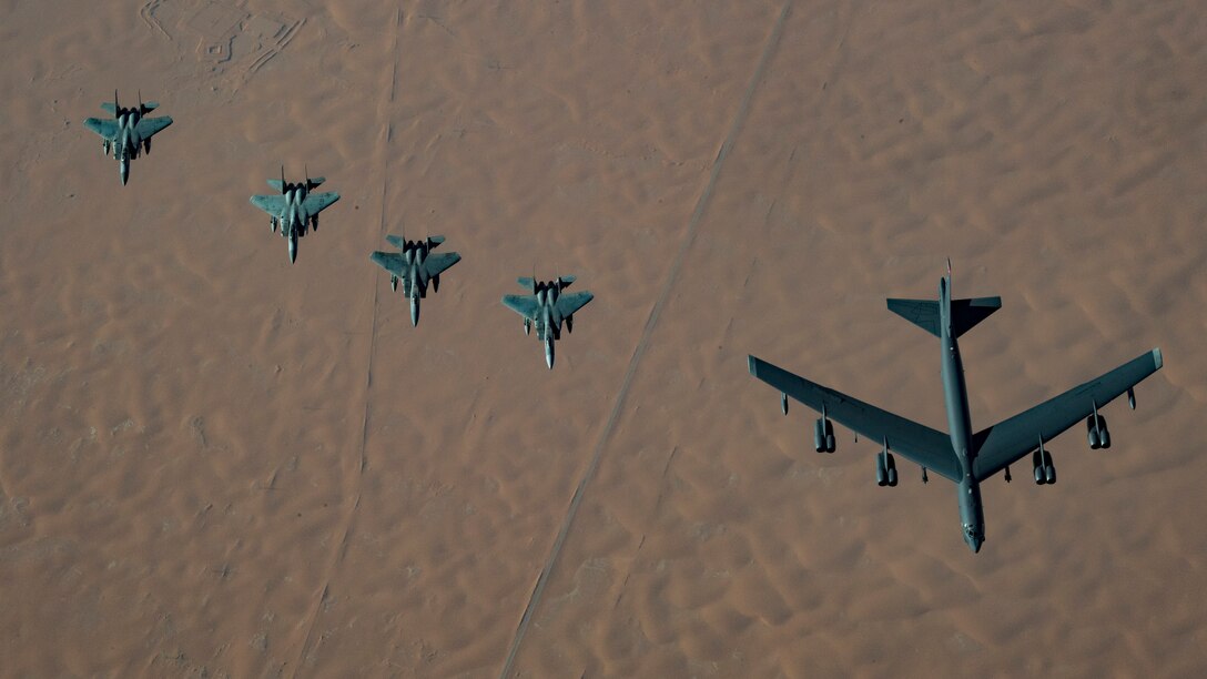 A United States Air Force B-52H Stratofortress, accompanied by four Saudi Arabian F-15C Eagles, conducts a low pass over Prince Sultan Air Base, Saudi Arabia, Nov. 1, 2019.