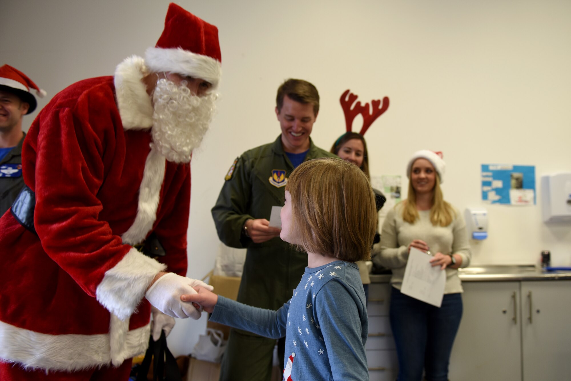 A child greets Father Christmas at the Duxford Children’s Christmas Party at the Imperial War Museum, Cambridgeshire, England, Dec. 14, 2019.  The Starlight Children’s Foundation, Bardet-Biedl Syndrome UK and Children's Burns Club charity organizations invited over 100 attendees to participate in the event. These organizations reach out to families with children who have serious or terminal illness, or with severe burns.(U.S. Air Force photo by Airman 1st Class Rhonda Smith)