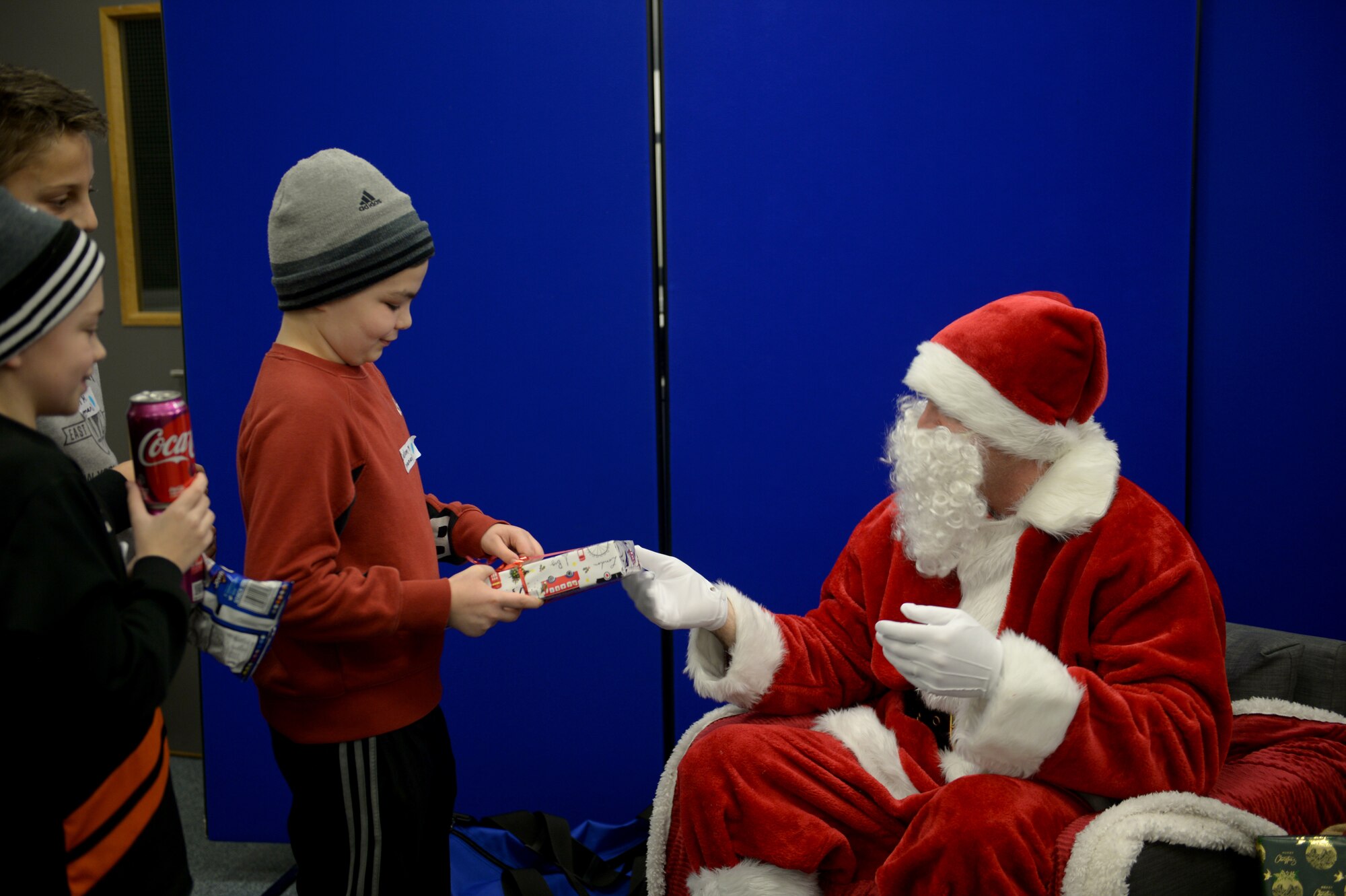A child receives a gift from Father Christmas at the Duxford Children’s Christmas Party at the Imperial War Museum, Cambridgeshire, England, Dec. 14, 2019. The 492nd Madhatter’s have carried on the Duxford Christmas Party tradition for the past 12 years. (U.S. Air Force photo by Airman 1st Class Rhonda Smith)