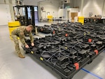 Staff Sgt. Zachary Casey of the Kentucky National Guard helps unload plastic crates containing the new Army Combat Fitness Test (ACFT) equipment Dec. 11, 2019, in Frankfort, Kentucky.