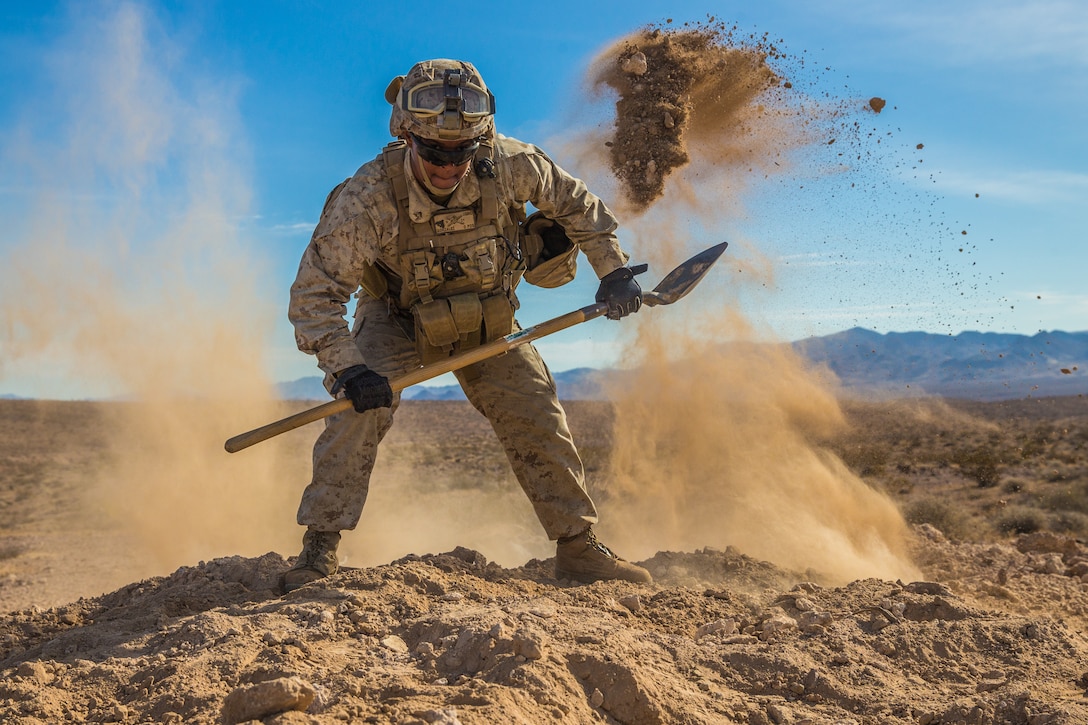 U.S. Marine Corps Cpl. Rayfel Gonzalez, a field artillery cannoneer with Kilo Battery, 3rd Battalion, 11th Marines, 1st Marine Division, digs an entrenchment for an M240B machine gun during exercise Steel Knight 20 on Marine Air-Ground Combat Center, Twentynine Palms, California, Dec. 11, 2019. SK20 increases the ability of all participants to plan, communicate and conduct operations against a capable near-peer adversary with a focus on a major combat maneuvers and sustainment.