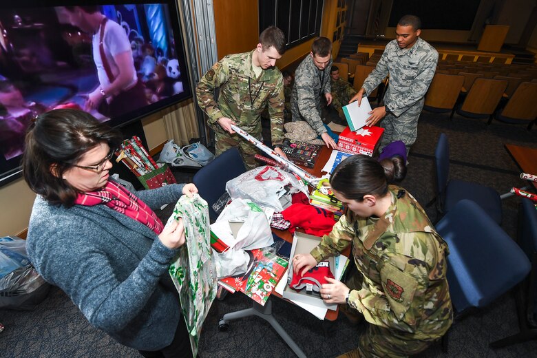Team Schriever members wrap gifts during the 50th Space Wing Chaplain's office hosted Angel Tree toy drive gift wrapping event, Dec. 16, 2019, in the Building 300 Auditorium at Schriever Air Force Base, Colorado. Airmen came together to wrap a variety of donated gifts which will be given to community families in need of assistance this year. (U.S. Air Force photo by Kathryn Calvert)