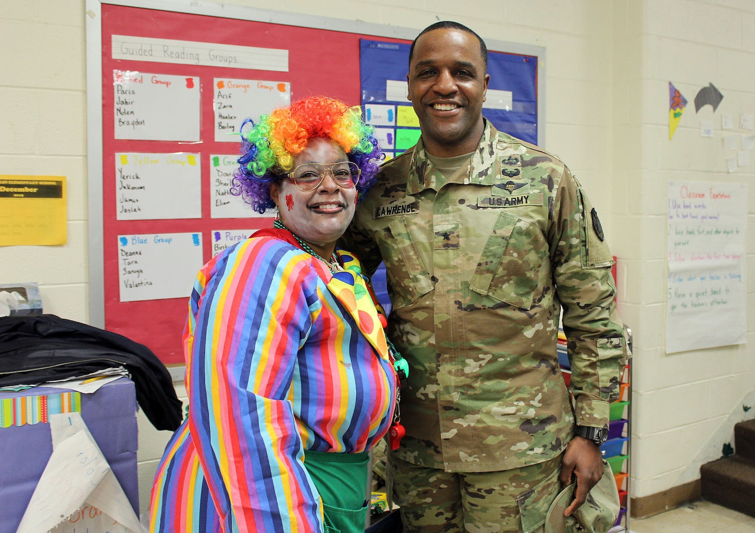 Crystal Robinson, a DLA Troop Support volunteer, left, and Army Brig. Gen. Gavin Lawrence, DLA Troop Support commander, right, pose for a photo during the Children’s Holiday Party Dec. 12, 2019 in Philadelphia.