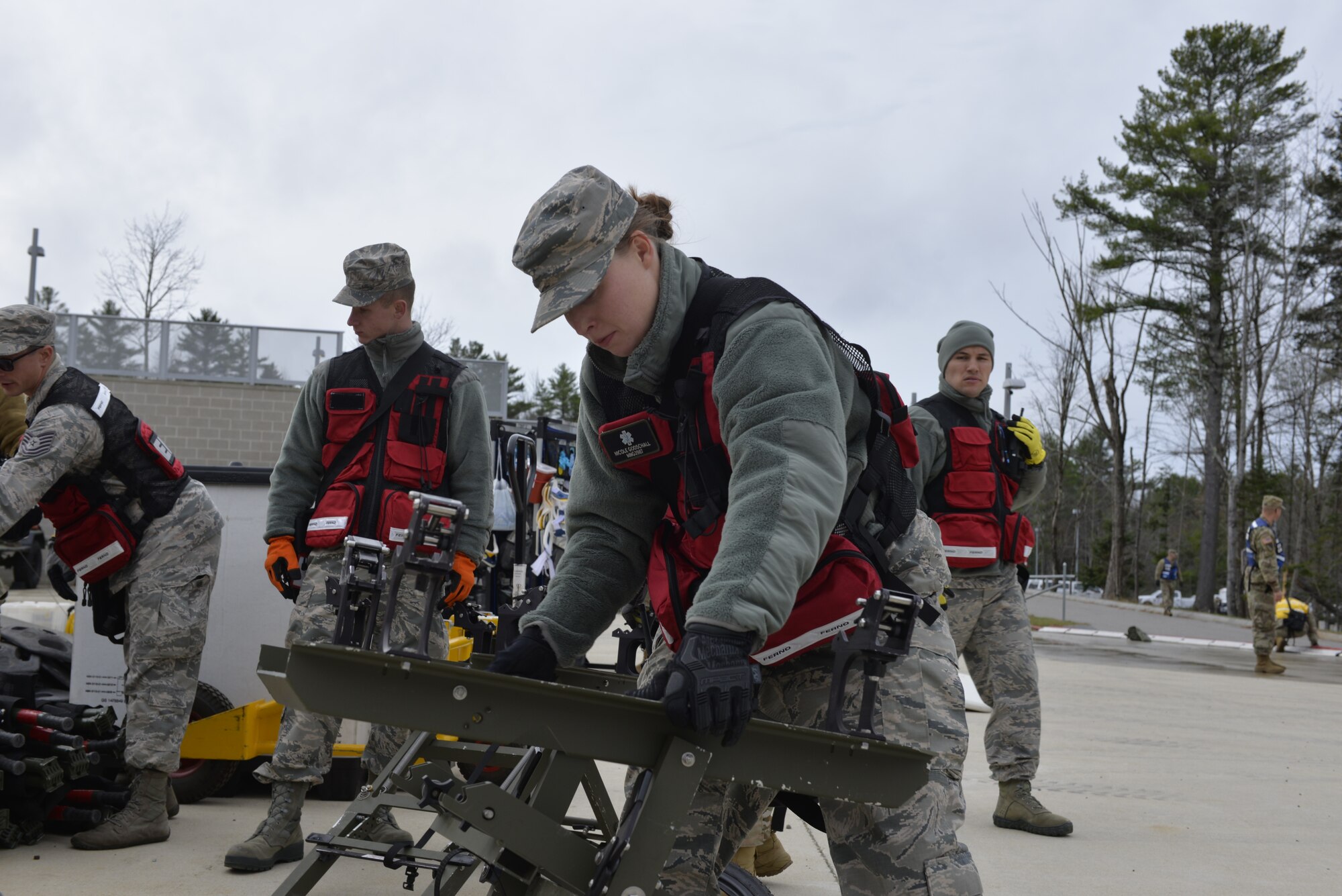 Tech. Sgt. Nicole Godschall, an aerospace medical technician with the 157th Medical Group, Detachment 1, New Hampshire Air National Guard, sets up a litter carrier during a New England CERFP mass casualty training exercise, Nov. 5, 2019, Brunswick, Maine. The exercise simulated the collapse of a chemical manufacturing building. (U.S. Air National Guard photo by Tech. Sgt. Aaron Vezeau)