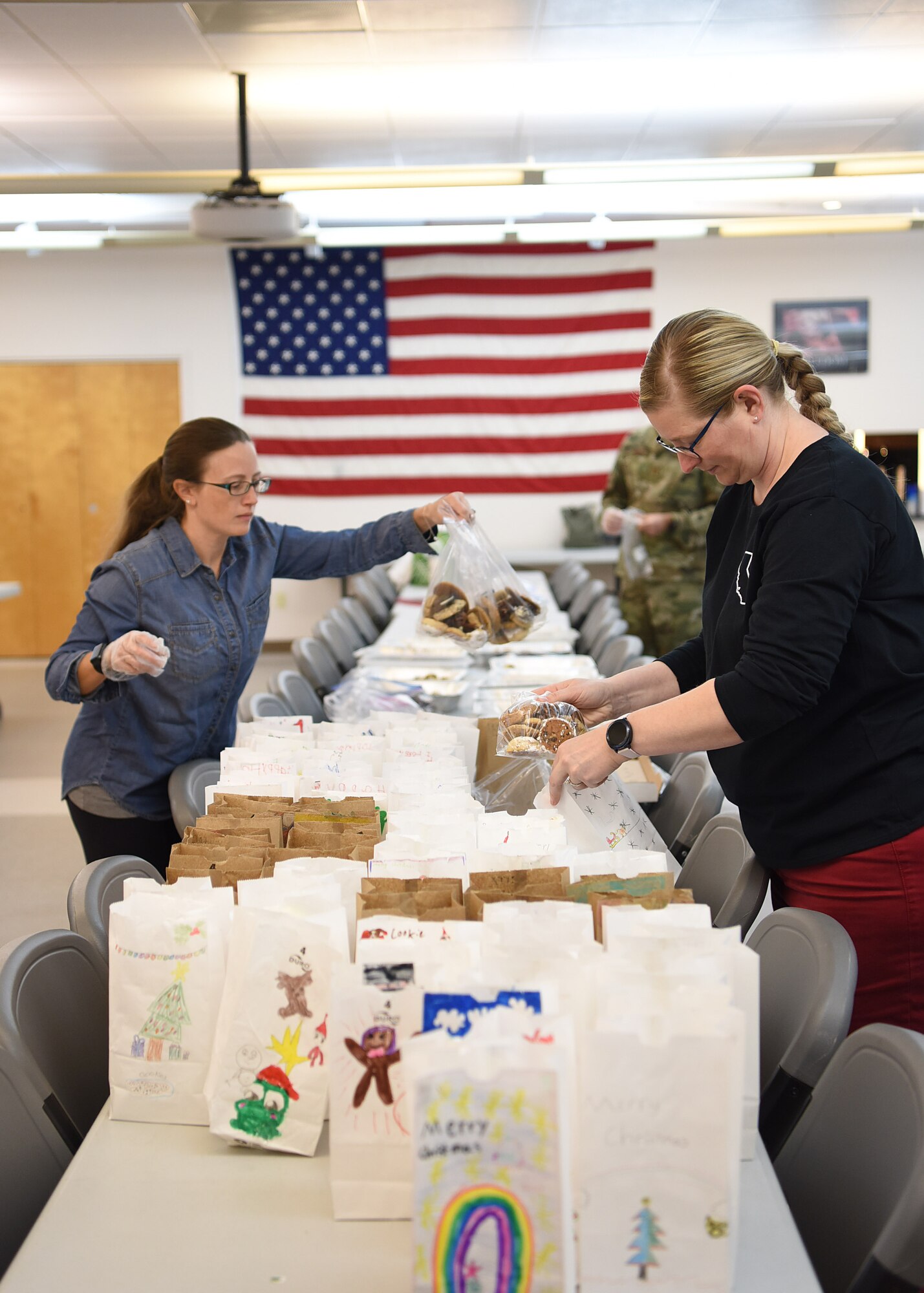 Vandenberg Air Force Base Spouse’s Club members bag cookies for the 2019 Cookie Drive Dec. 16, 2019, at VAFB, Calif. During the drive, VAFB Spouse’s Club members packaged cookies in bags decorated by students from local schools and delivered the bags to Airmen across the base.  (U.S. Air Force photo by Airman 1st Class Hanah Abercrombie)