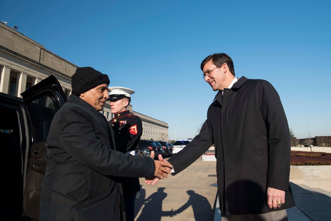 Two men shake hands.