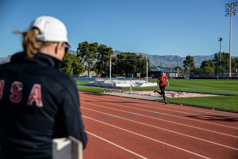 Trainer watches athlete train