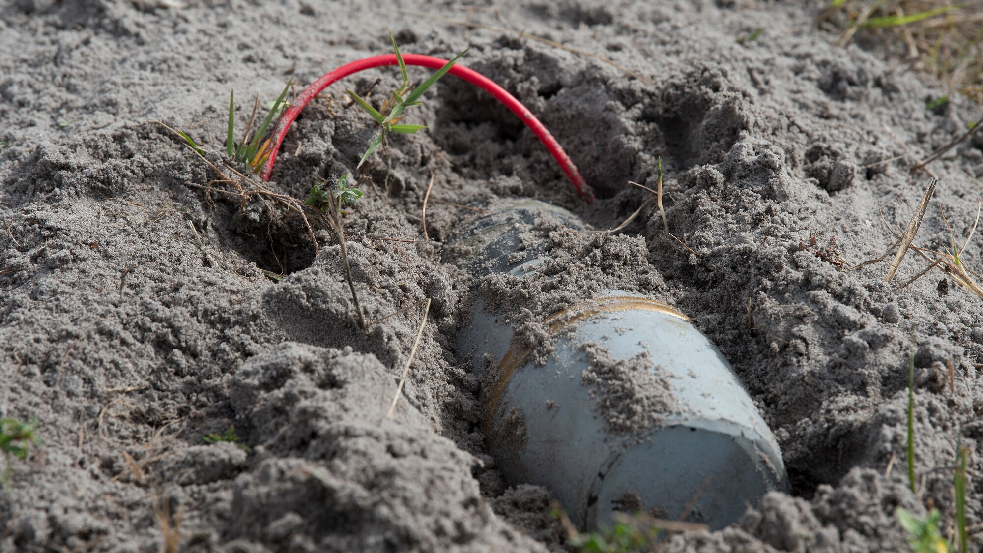 A simulated improvised explosive device (IED) is uncovered during a field training exercise Dec. 11, 2019, at Avon Park Air Force Range, Fla.  The 6th Civil Engineer Squadron explosive ordnance flight and the 6th Security Forces Squadron military working dog handlers, teamed up to better integrate training for detecting and securing IEDs.