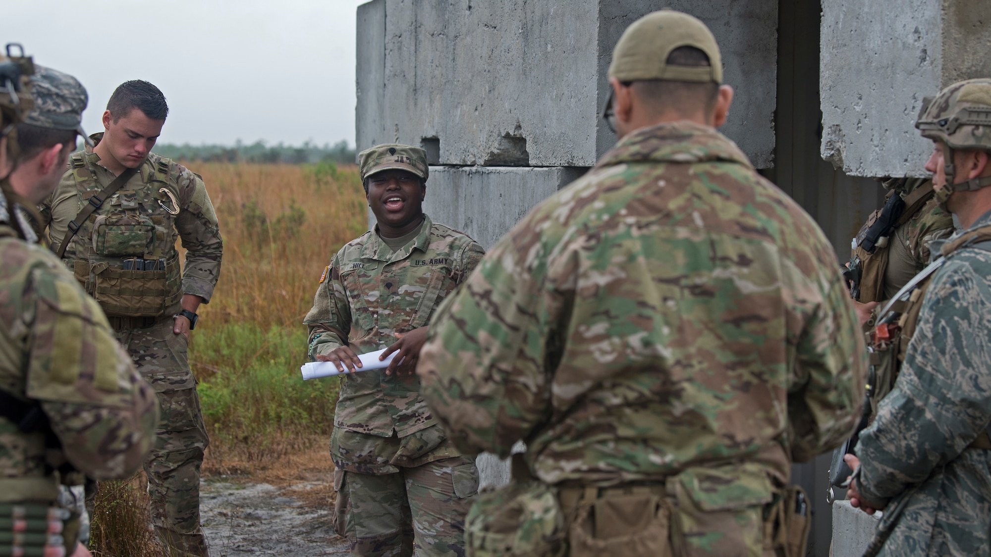 U.S. Army Spc. Malaysia Hill, a veterinary technician with Public Health Activity, Fort Gordon, MacDill branch veterinary service, gives a briefing, to U.S. Air Force Airmen from MacDill Air Force Base, Fla., on how to provide emergency care to military working dogs (MWD), during a field training exercise Dec. 11, 2019, at Avon Park Air Force Range, Fla.  Hill advised the Airmen on procedures and precautions to ensure the health and wellbeing of MWDs, while in high threat scenarios.