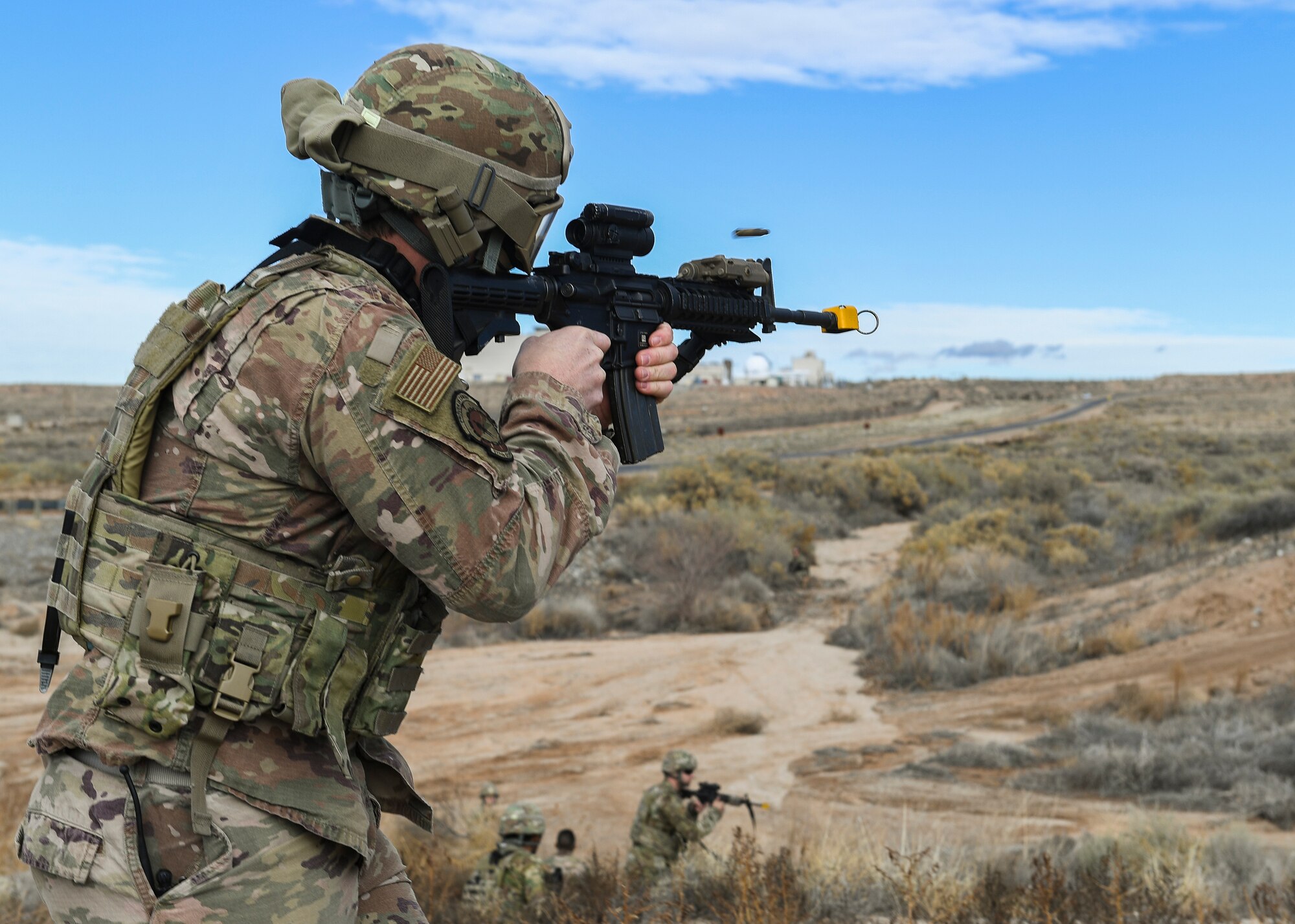 A security forces member fires blank rounds at opposing forces during an exercise.