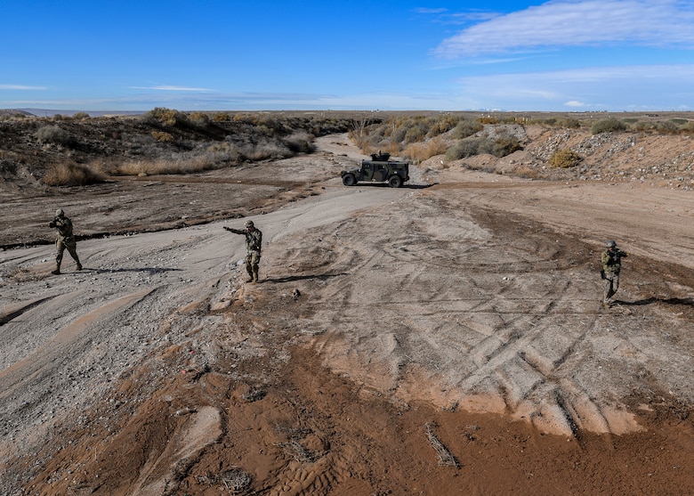Security forces members advance to opposing forces during an exercise.