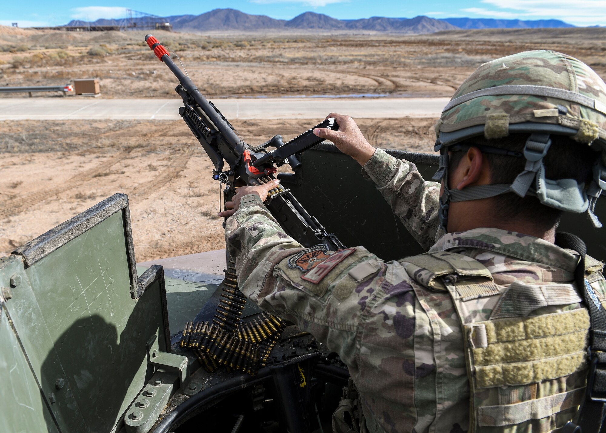 A security forces member loads a M240B machine gun.