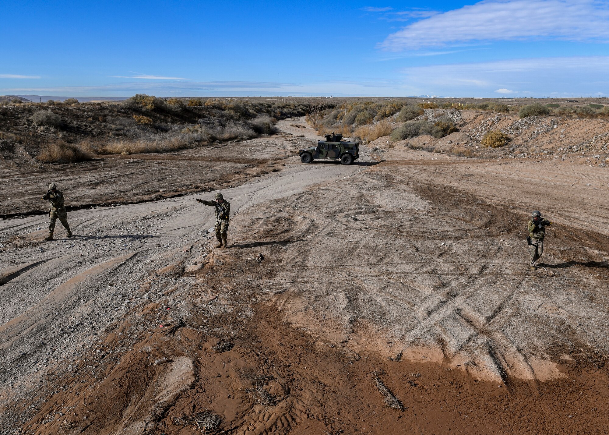 Security forces members advance to opposing forces during an exercise.