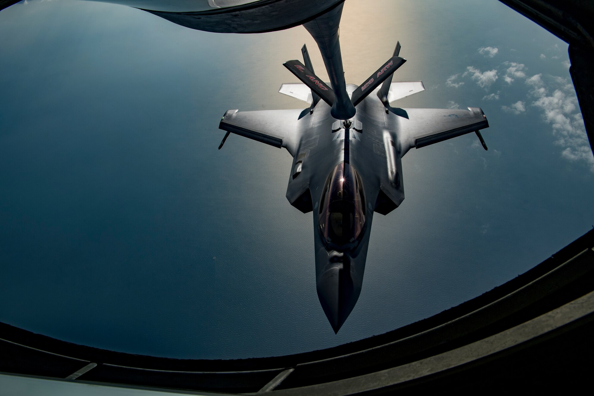 A U.S. Air Force KC-135 Stratotanker boom operator with the 28th Expeditionary Air Refueling Squadron conducts an aerial refueling, giving gas to a U.S. Air Force F-35A Lightning II assigned to the 34th Expeditionary Fighter Squadron above the Arabian Gulf, Dec. 3, 2019.