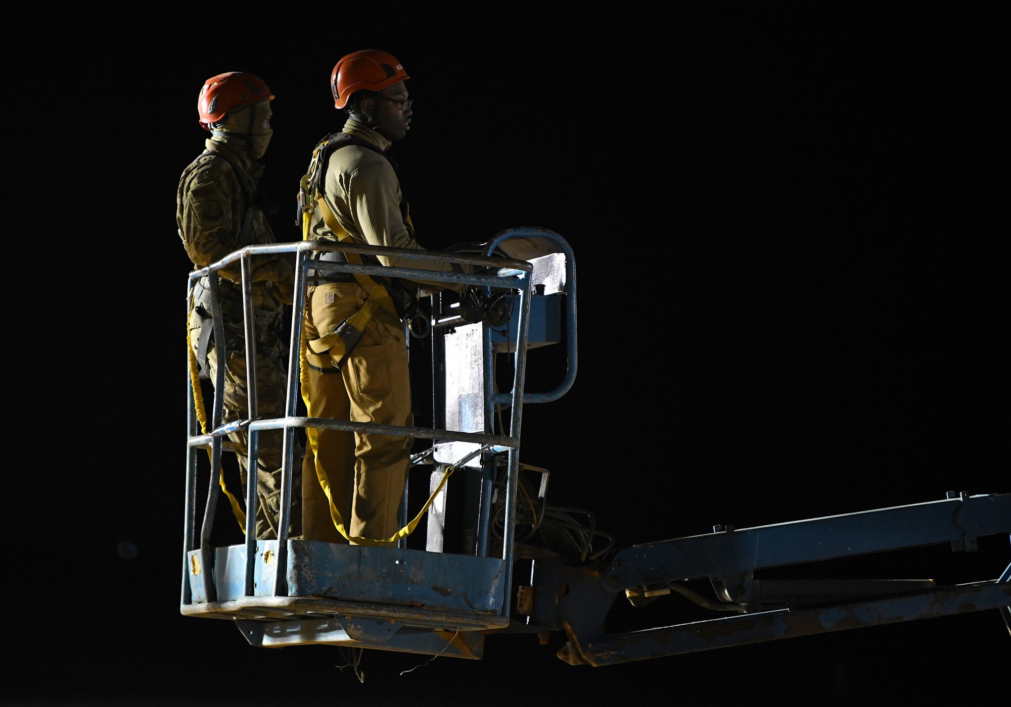 U.S. Airmen deployed with the 819th Expeditionary Rapid Engineer Deployable Heavy Operational Repair Squadron Engineer team rise up to their work area using a lift during the construction of a new hangar at Nigerien Air Base 201, Niger, Dec. 13, 2019. In Niger, deployed RED HORSE teams are continually improving base infrastructure and building new facilities for current and future missions. (U.S. Air Force photo by Staff Sgt. Alex Fox Echols III)