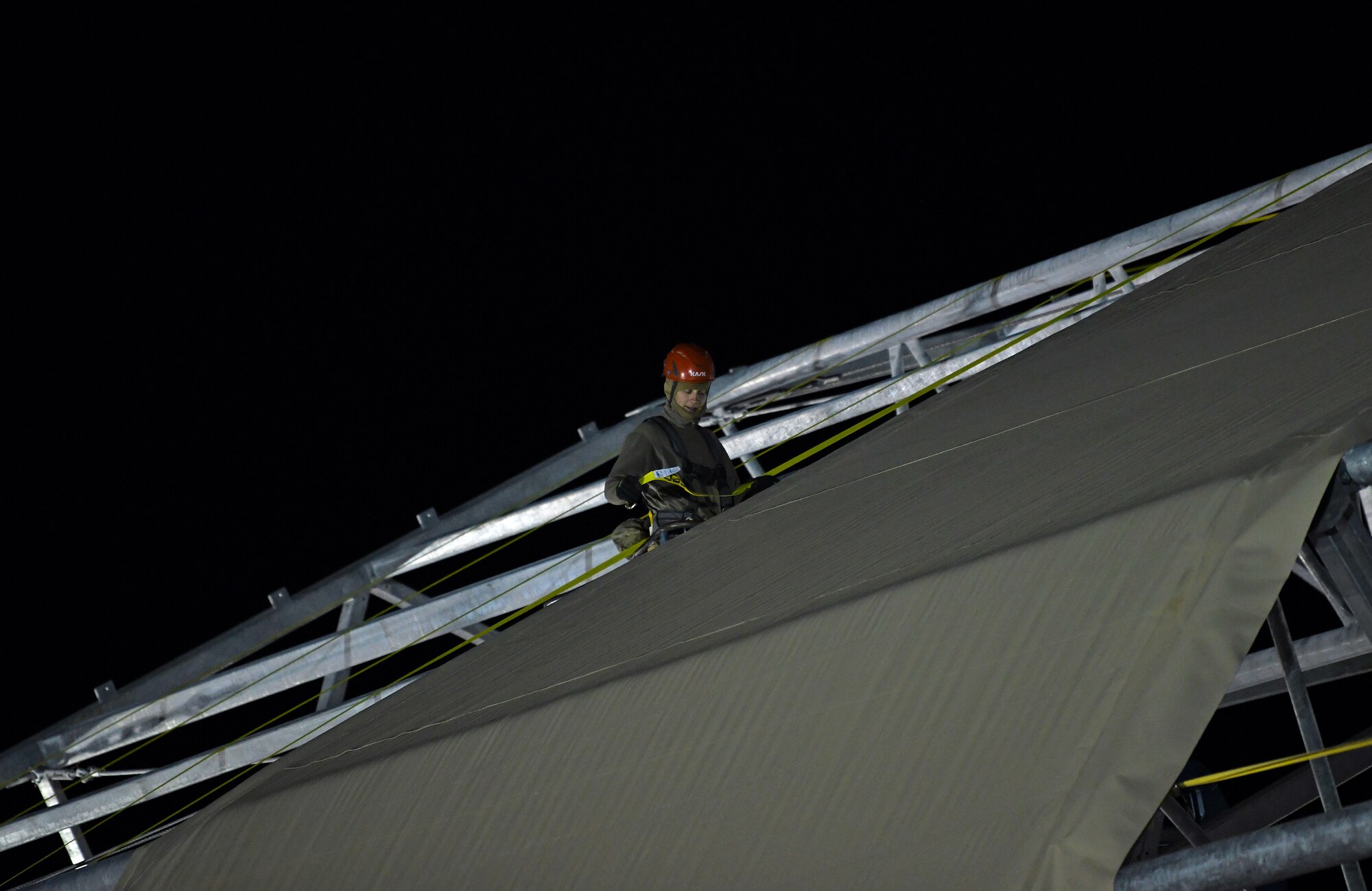 A U.S. Airman deployed with the 819th Expeditionary Rapid Engineer Deployable Heavy Operational Repair Squadron Engineer team secures a side panel on a new hangar at Nigerien Air Base 201, Niger, Dec. 13, 2019. In Niger, deployed RED HORSE teams are continually improving base infrastructure and building new facilities for current and future missions. (U.S. Air Force photo by Staff Sgt. Alex Fox Echols III)
