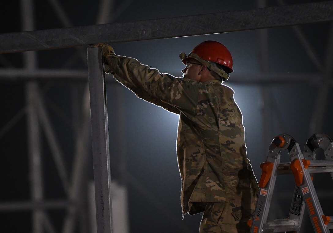 A U.S. Airman deployed with the 819th Expeditionary Rapid Engineer Deployable Heavy Operational Repair Squadron Engineer team secures a door frame on a new hangar at Nigerien Air Base 201, Niger, Dec. 13, 2019. In Niger, deployed RED HORSE teams are continually improving base infrastructure and building new facilities for current and future missions. (U.S. Air Force photo by Staff Sgt. Alex Fox Echols III)