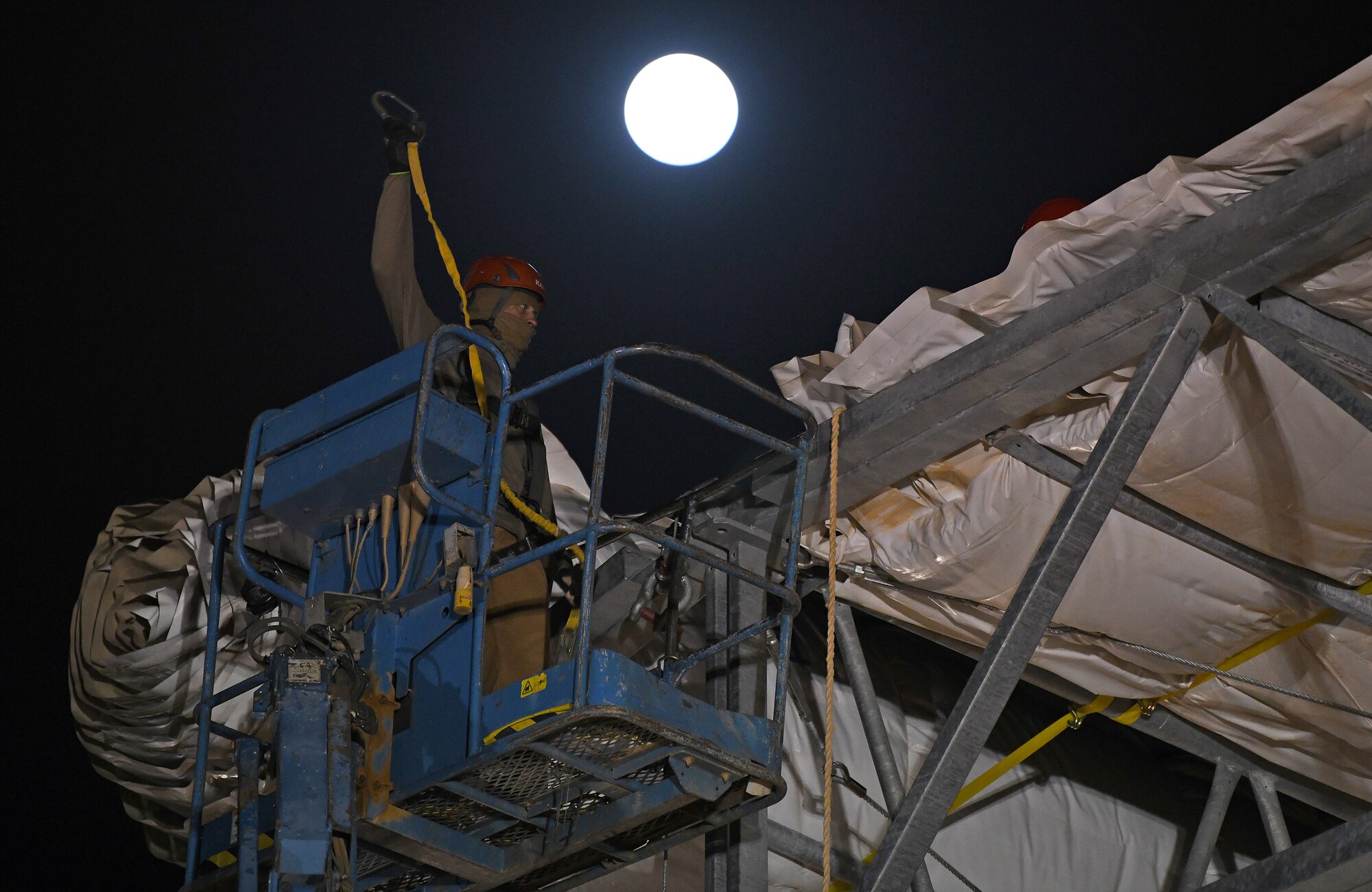 A U.S. Airman deployed with the 819th Expeditionary Rapid Engineer Deployable Heavy Operational Repair Squadron Engineer team secures his harness at Nigerien Air Base 201, Niger, Dec. 13, 2019. In Niger, deployed RED HORSE teams are continually improving base infrastructure and building new facilities for current and future missions. (U.S. Air Force photo by Staff Sgt. Alex Fox Echols III)