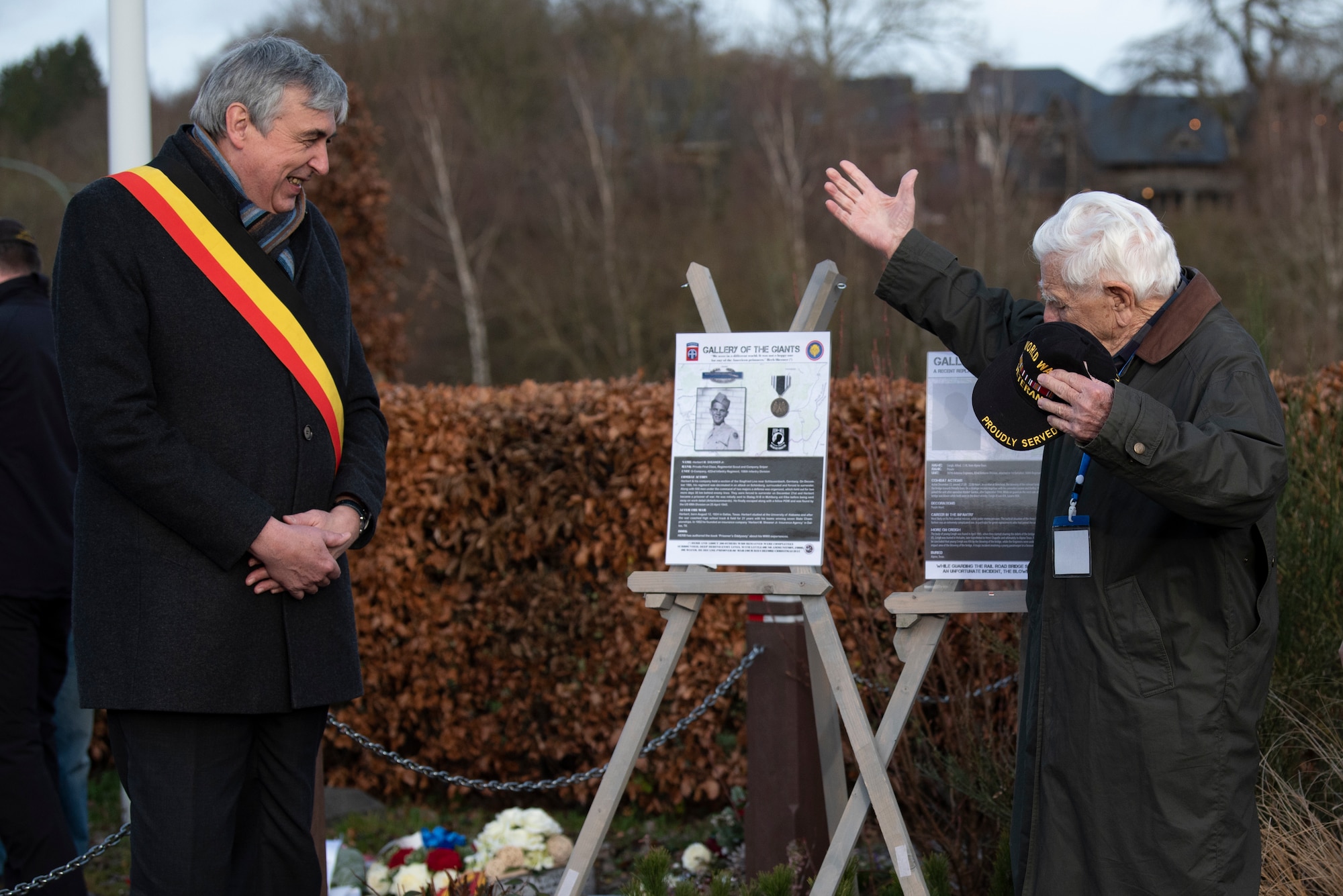 Elie Deblire, left, mayor of Vielsalm, Belgium, presents a memorial poster of Herbert Sheaner, right, U.S. Army veteran and former prisoner of war. Sheaner became a POW during the Battle of the Bulge 75 years ago and was inducted into the "Gallery of the Giants" during a memorial ceremony in Vielsalm. (U.S. Air Force photo by Airman 1st Class Alison Stewart)