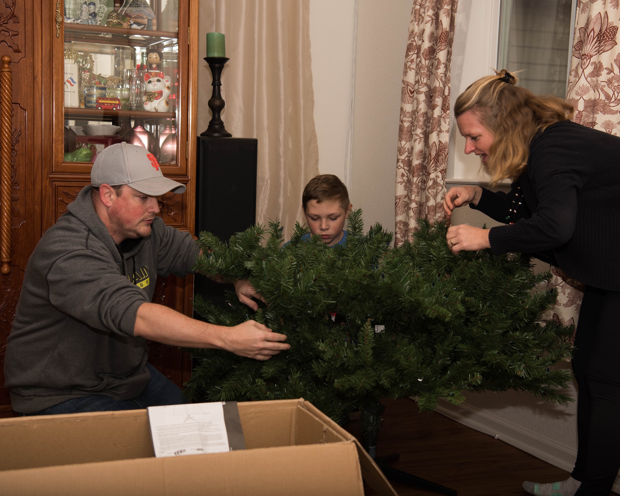 Volunteers help erect a tree during Dec’ the Deployment in Hampton, Virginia, Dec. 11, 2019.