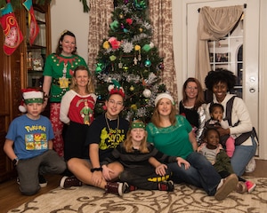 Volunteers pose with the Epp family in front of their newly decorated tree during Dec’ the Deployment in Hampton, Virginia, Dec. 11, 2019.