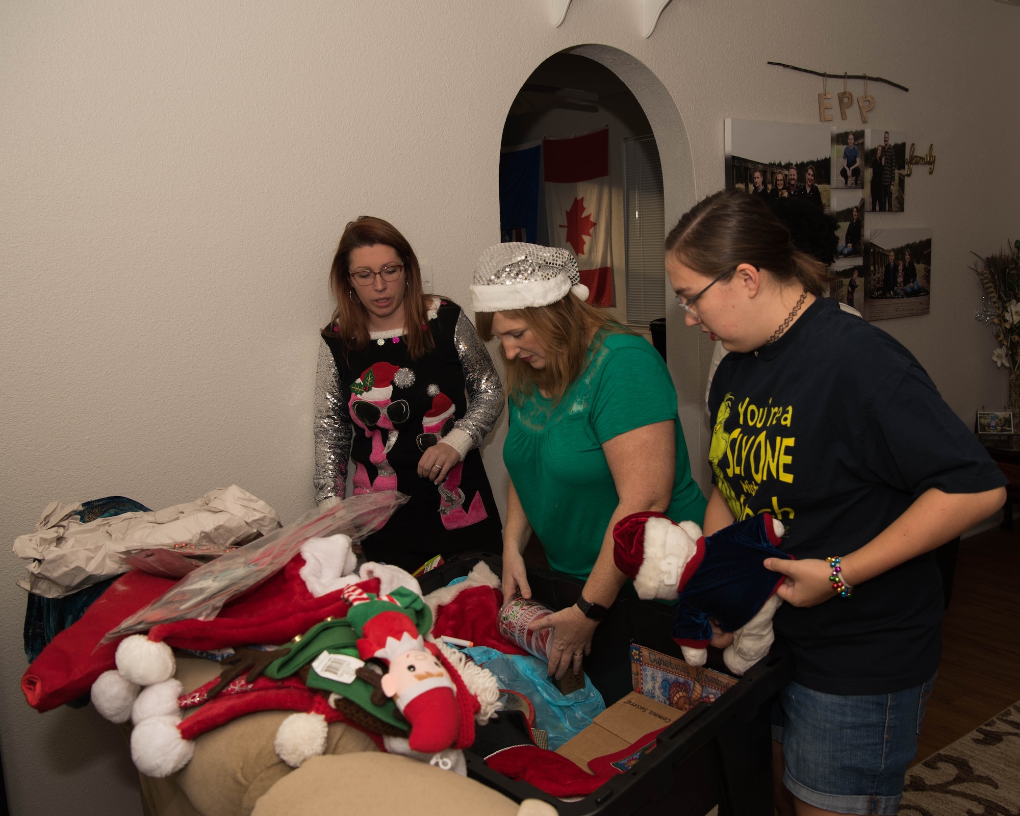 Katelyn Tinsley (left),founder and lead designer of the Dec’ the Deployment initiative, helps members of the Epp family sort through ornaments during Dec’ the Deployment in Hampton, Virginia, Dec. 11, 2019.