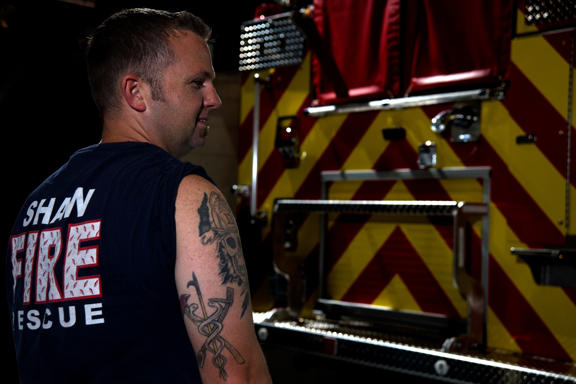 Photo of a Team Shaw members displaying a tattoo representing the fire and life-saving aspects of his job