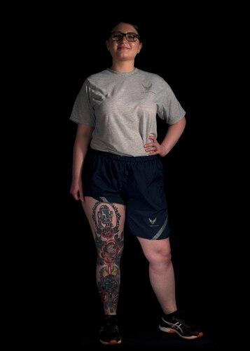 Photo of an Airman displaying a tattoo representing her childhood and relationship with her father