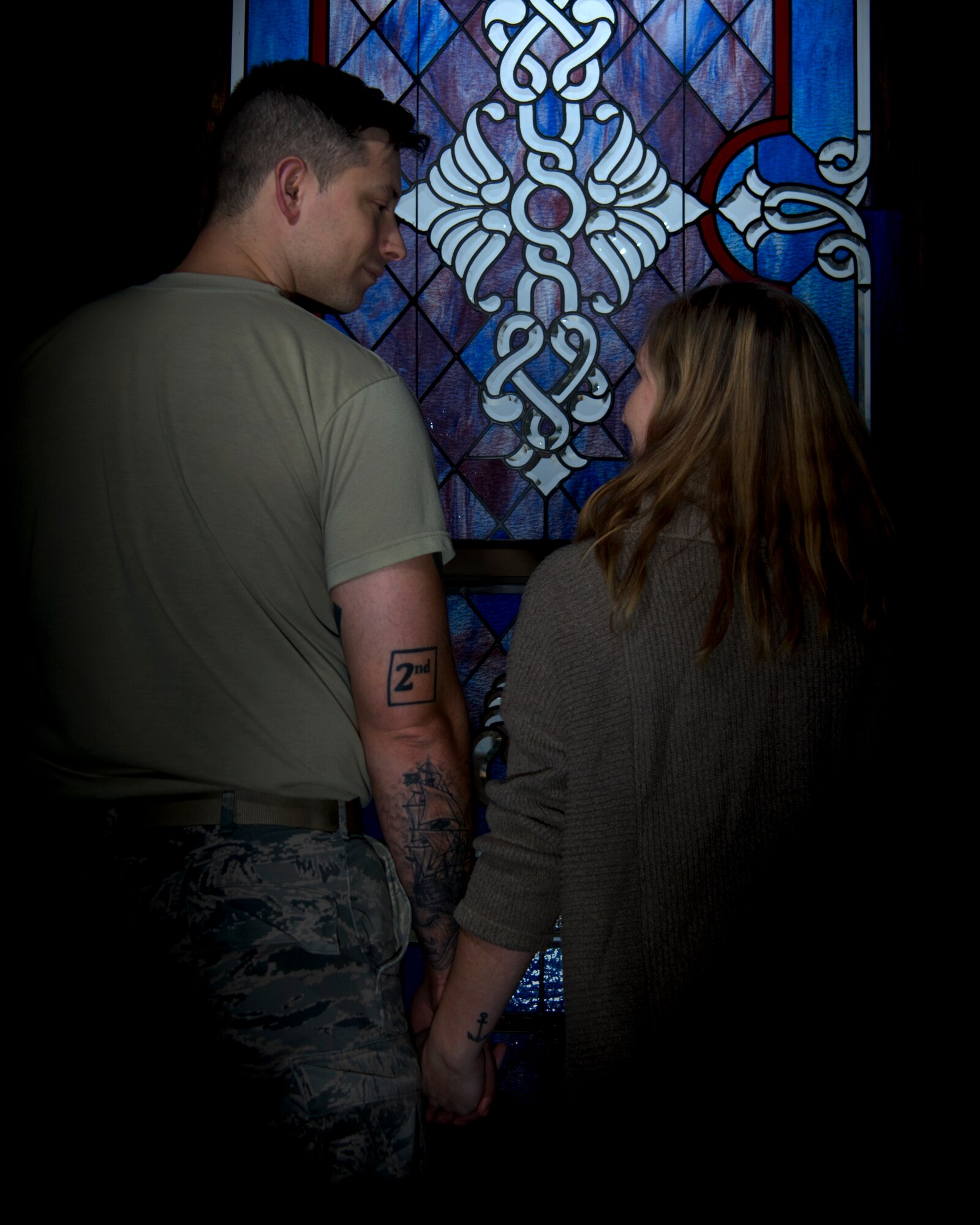 Photo of an Airman and his wife displaying their marriage tattoos