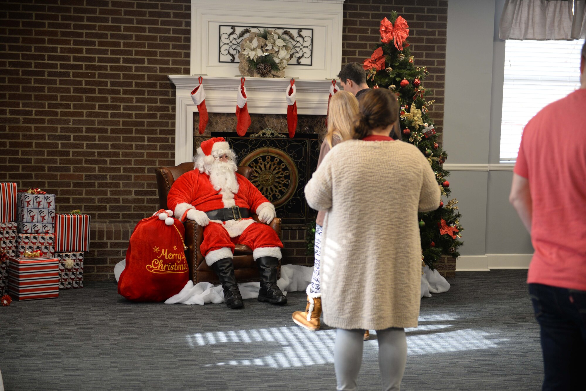 Families and children wait in line to get photos with Santa Claus during Breakfast with Santa in the Columbus Club Dec. 14, 2019, on Columbus Air Force Base, Miss. According to legend, Santa lives in the North Pole with Mrs. Claus, the elves and their reindeer. (U.S. Air Force photo by Airman 1st Class Hannah Bean)