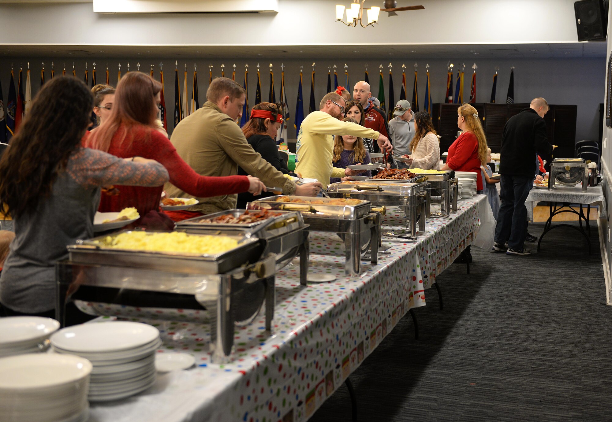 Families and friends fill plates with food during Breakfast with Santa in the Columbus Club Dec. 14, 2019, on Columbus AFB, Miss. A variety of activities were provided at the event, to include various games, crafts, face painting and more. (U.S. Air Force photo by Airman 1st Class Hannah Bean)