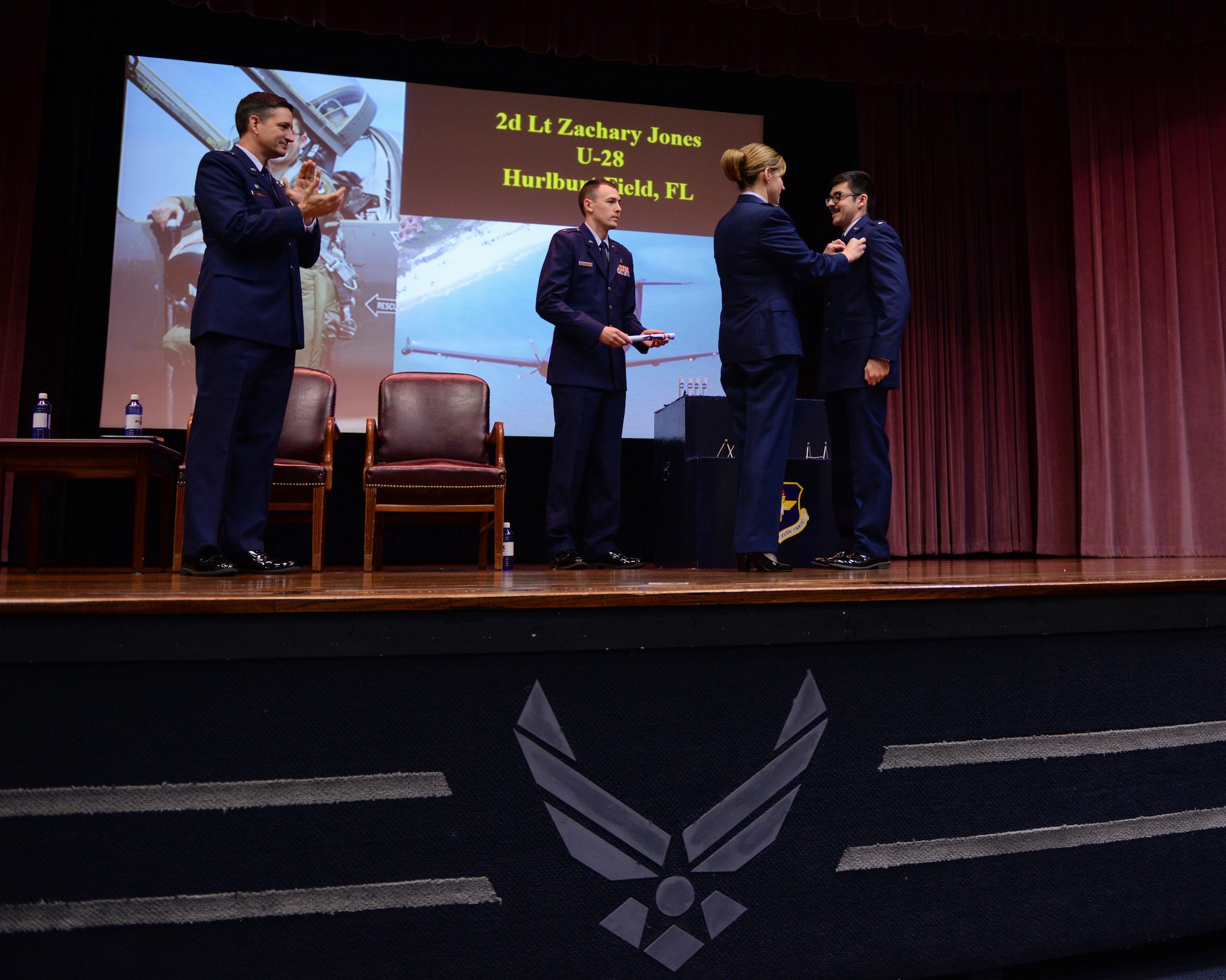 Col. Samantha Weeks, 14th Flying Training Wing commander, pins on a pair of “silver wings” to a graduate of Specialized Undergraduate Pilot Training Class 20-04/05, Dec. 13, 2019, at Columbus Air Force Base, Miss. As a tradition, pilots will break their first pair of “silver wings” for good luck. (U.S. Air Force photo by Airman Davis Donaldson)