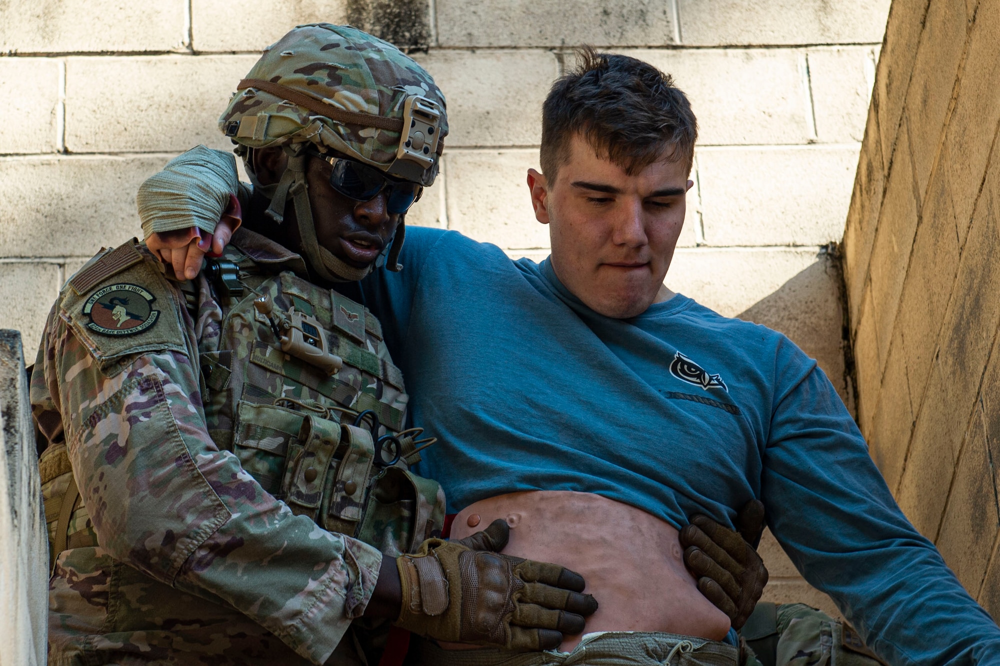 Photo of an Airman assisting a simulated victim during the Combat Lifesavers Course
