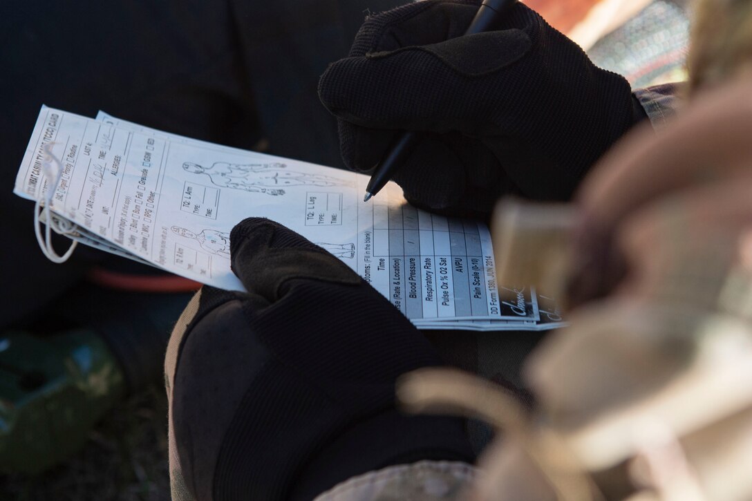 Photo of an Airman filling out a tactical combat casualty card during the Combat Lifesavers Course.