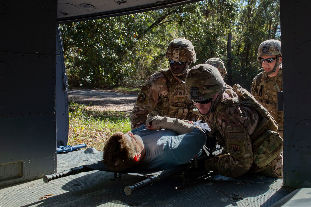 Photo of Airmen loading a simulated victim onto a training fuselage during the Combat Lifesavers Course.