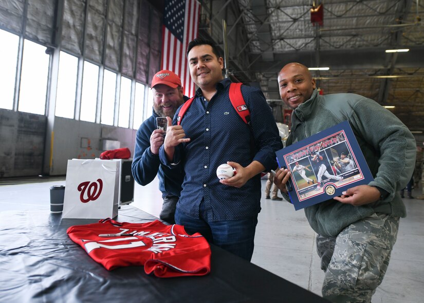 Washington Nationals fans pose for a photo with their soon-to-be-signed souveniers during a World Series display event at Joint Base Andrews, Md., Dec. 17, 2019. Fans brought items to be signed by Ryan Zimmerman, Washington Nationals first baseman. (U.S. Air Force photo by Airman 1st Class Spencer Slocum)