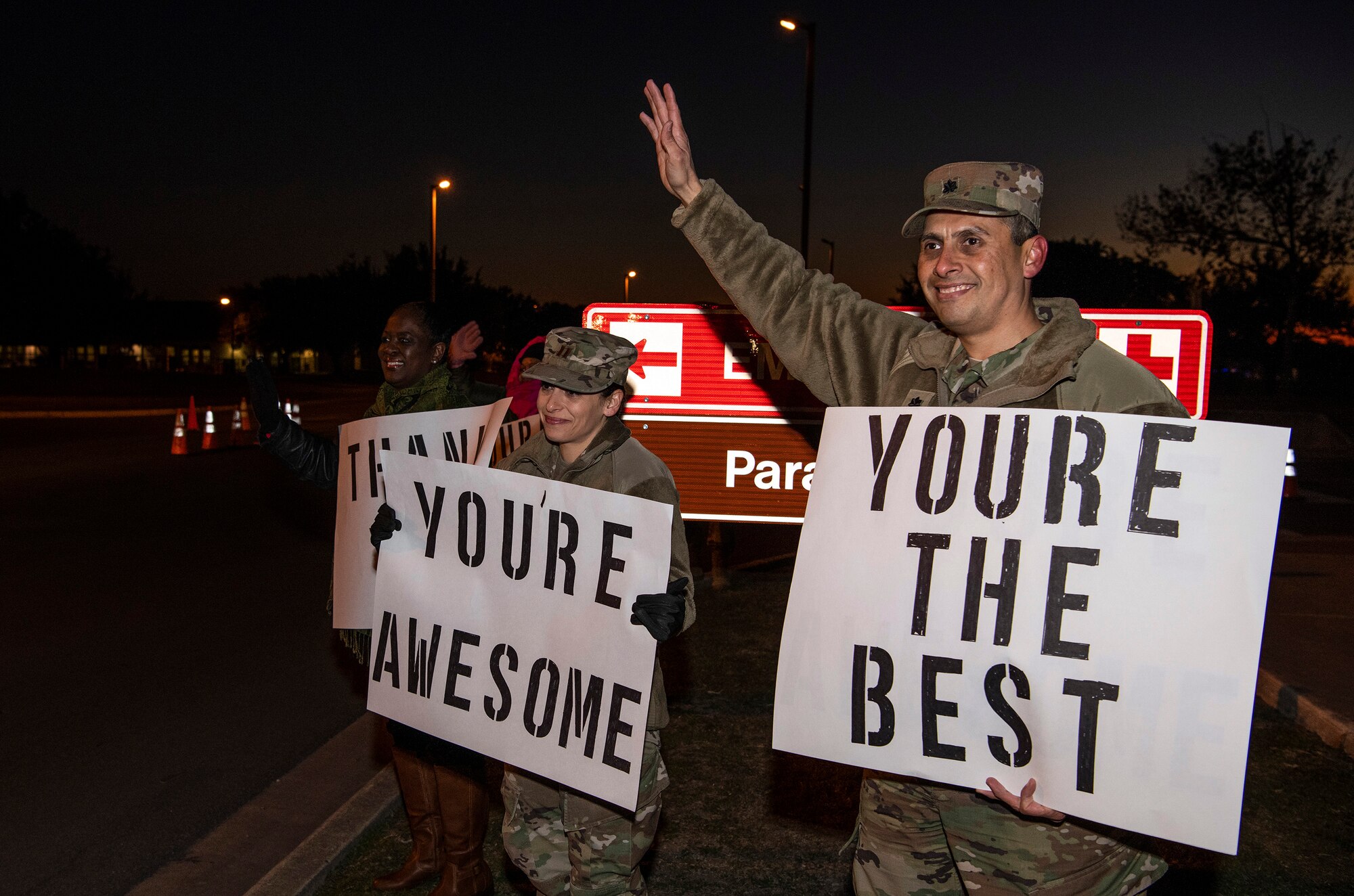 From right, Lt. Col. Raymundo Vann, 323rd Training Squadron commander, Capt. Jessica Stanley, 737th Training Group and Lydia Davidson, wife of Col. Isaac Davidson, Inter-American Air Forces Academy commandant, hold positive messages of support at a base gate during the morning inbound commute as part of their new initiative, “We Care,” at Joint Base San Antonio-Lackland, Texas, Dec. 18, 2019. The initiative involved 37th Training Wing military and civilian members spending the morning at various gates letting each person know that they stand together in support of those struggling with depression and thoughts of suicide by holding a positive message of support and handing out over 400 candy canes. If you are struggling with thoughts of suicide, please go directly to the Mental Health Clinic or to your closest Emergency Room. You can also reach the National Suicide Prevention Lifeline at 1-800-273-8255.