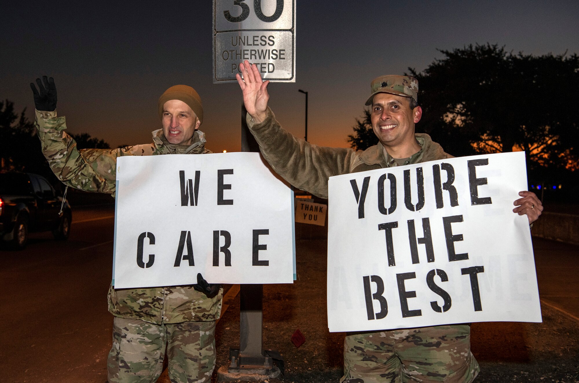 From left, Lt. Col. Scott Christensen, 331st Training Squadron commander, and Lt. Col. Raymundo Vann, 323rd Training Squadron commander, hold positive messages of support at a base gate during the morning inbound commute as part of their new initiative, “We Care,” at Joint Base San Antonio-Lackland, Texas, Dec. 18, 2019. The initiative involved 37th Training Wing military and civilian members spending the morning at various gates letting each person know that they stand together in support of those struggling with depression and thoughts of suicide by holding a positive message of support and handing out over 400 candy canes. If you are struggling with thoughts of suicide, please go directly to the Mental Health Clinic or to your closest Emergency Room. You can also reach the National Suicide Prevention Lifeline at 1-800-273-8255.