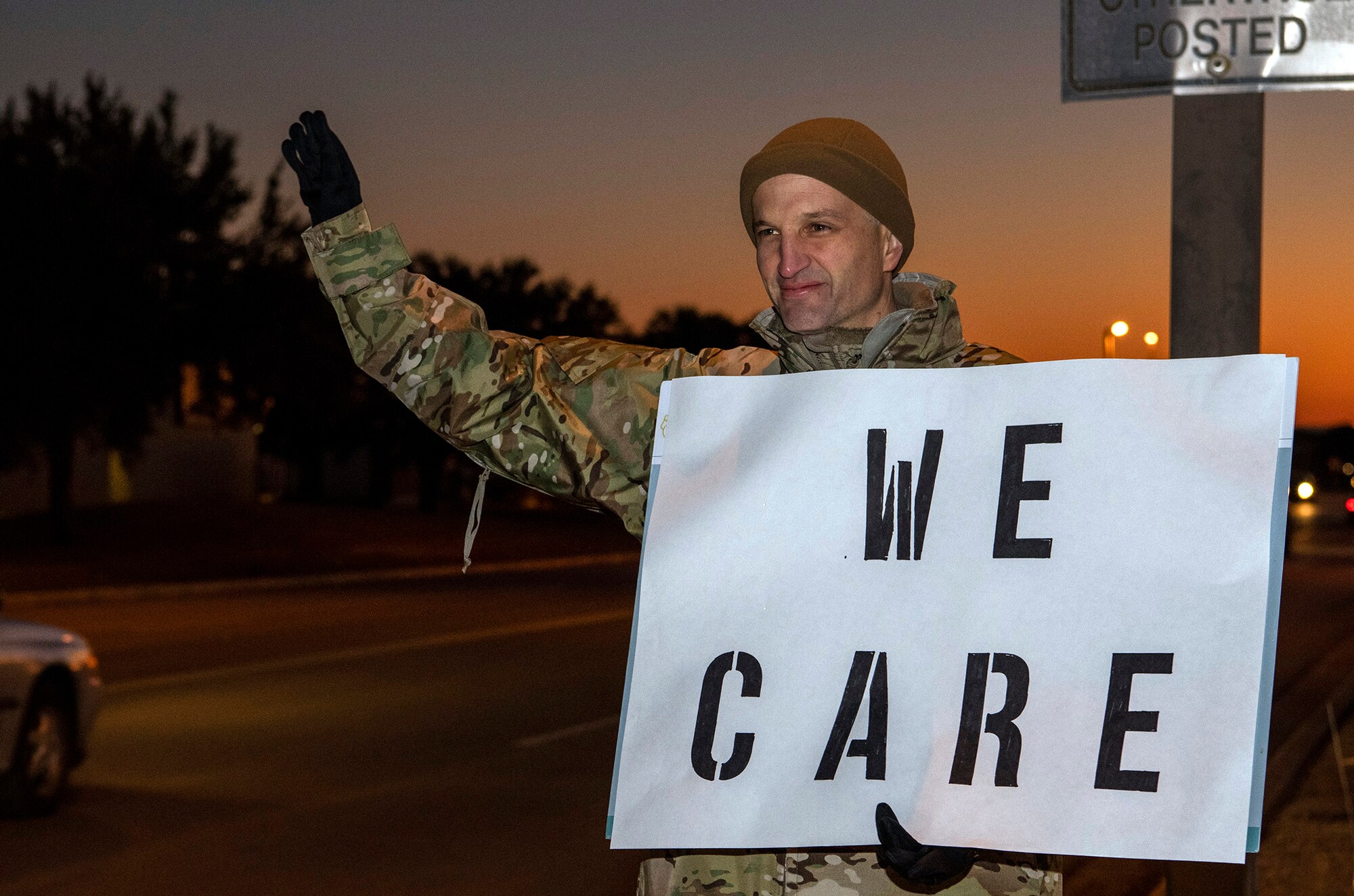 Lt. Col. Scott Christensen, 331st Training Squadron commander, holds a positive message of support at a base gate during the morning inbound commute as part of their new initiative, “We Care,” at Joint Base San Antonio-Lackland, Texas, Dec. 18, 2019. The initiative involved 37th Training Wing military and civilian members spending the morning at various gates letting each person know that they stand together in support of those struggling with depression and thoughts of suicide by holding a positive message of support and handing out over 400 candy canes. If you are struggling with thoughts of suicide, please go directly to the Mental Health Clinic or to your closest Emergency Room. You can also reach the National Suicide Prevention Lifeline at 1-800-273-8255.