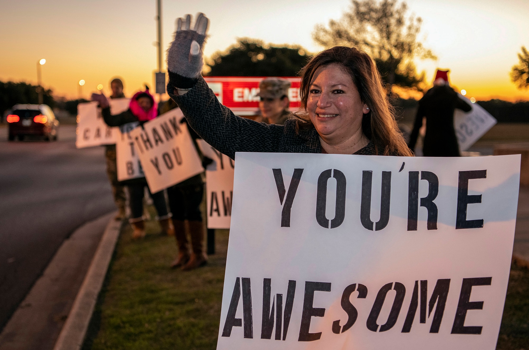 Jennifer Vann, “We Care,” organizer and wife of Lt. Col. Raymundo Vann, 323rd Training Squadron commander, holds a positive message of support at a base gate during the morning inbound commute as part of their new initiative, “We Care,” at Joint Base San Antonio-Lackland, Texas, Dec. 18, 2019. The initiative involved 37th Training Wing military and civilian members spending the morning at various gates letting each person know that they stand together in support of those struggling with depression and thoughts of suicide by holding a positive message of support and handing out over 400 candy canes. If you are struggling with thoughts of suicide, please go directly to the Mental Health Clinic or to your closest Emergency Room. You can also reach the National Suicide Prevention Lifeline at 1-800-273-8255.